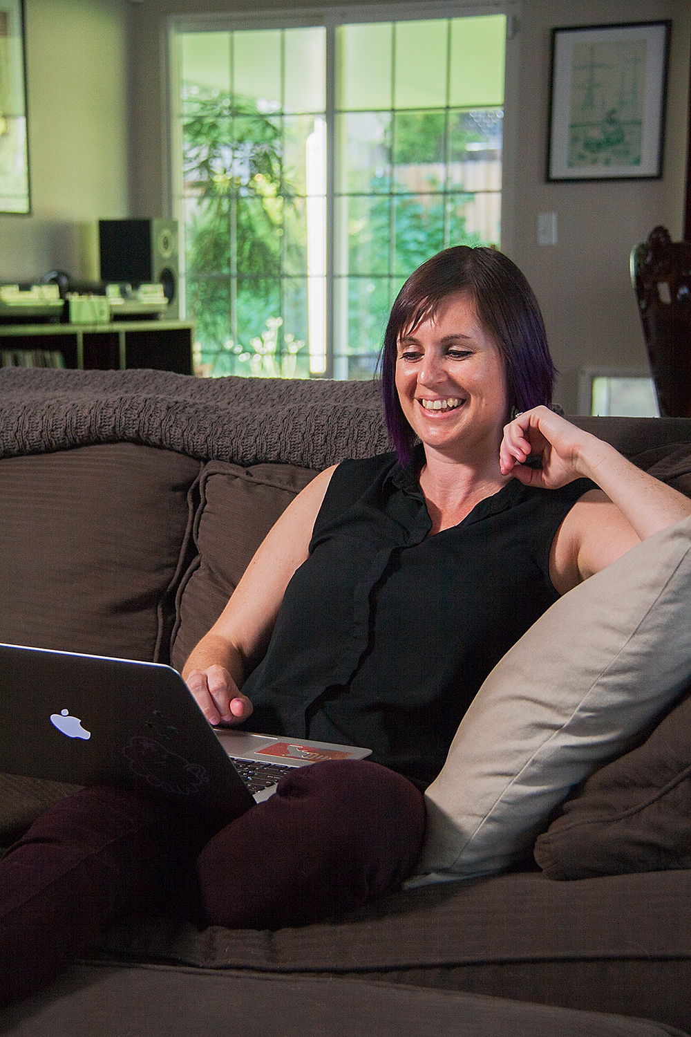 Jamie Louise Molaro smiling on the couch.